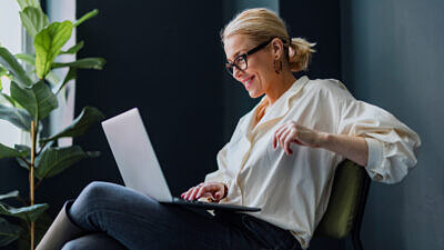 Mulher de negócios feliz usando laptop no escritório