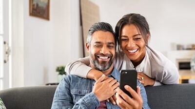 Casal feliz usando smartphone em casa