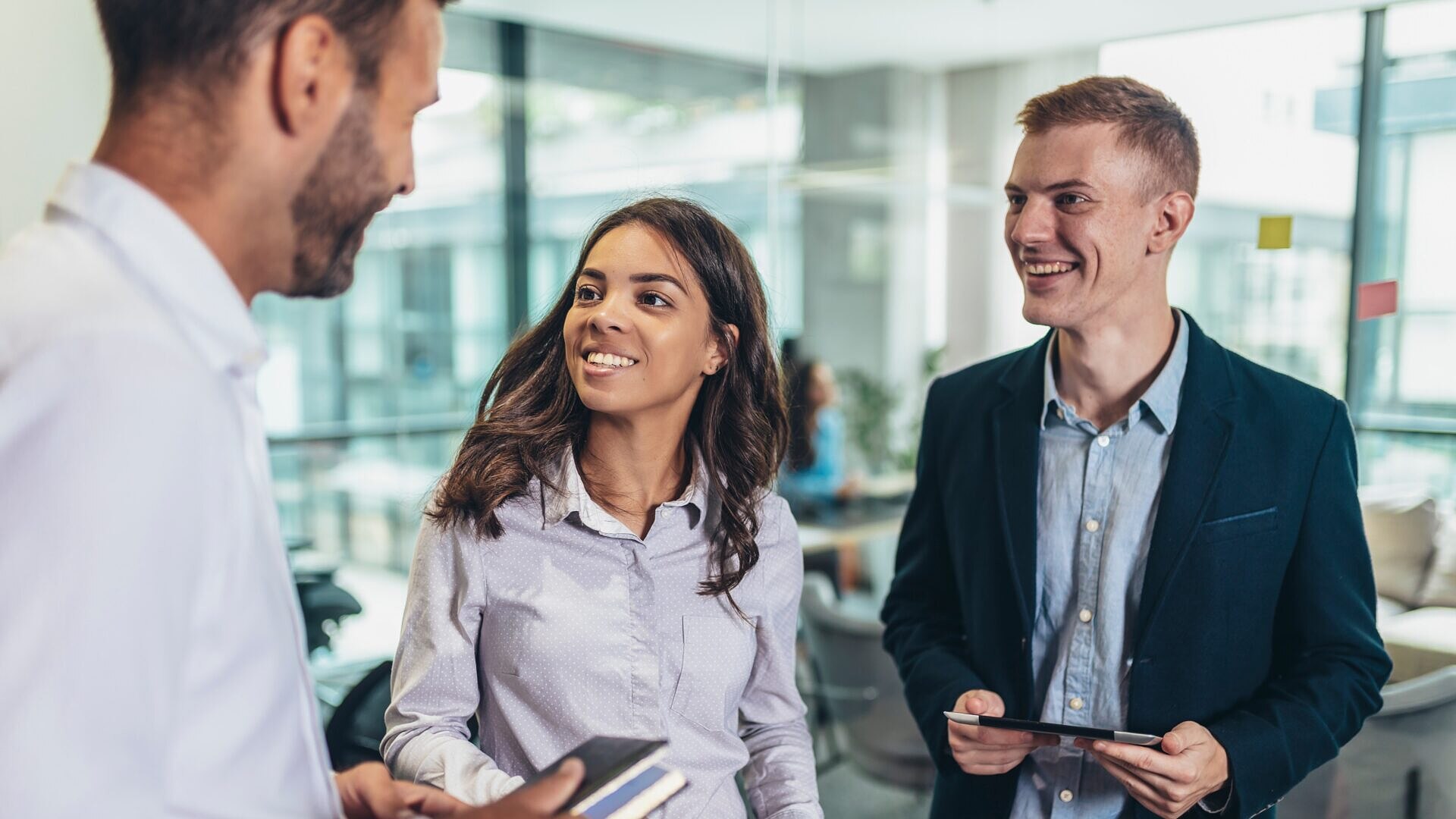 Dois jovens adultos no escritório conversando com um homem