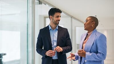 Um homem e uma mulher conversando no escritório