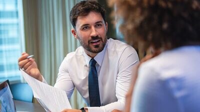 Um homem vestido de social conversando com uma mulher