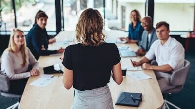 Uma diretora fazendo reunião com outros colaboradores
