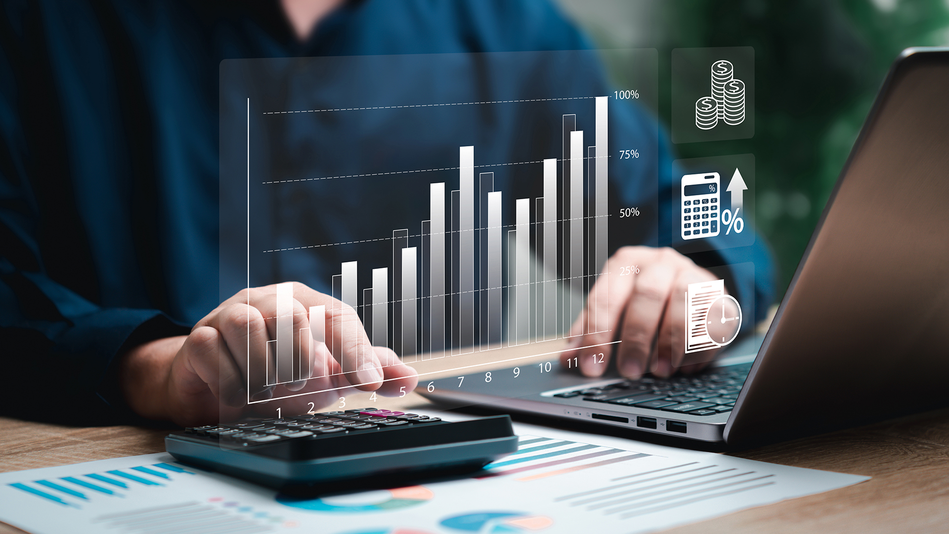 Mãos digitando no computador e calculadora com gráficos