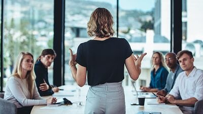Mulher líder falando com uma equipe de trabalho