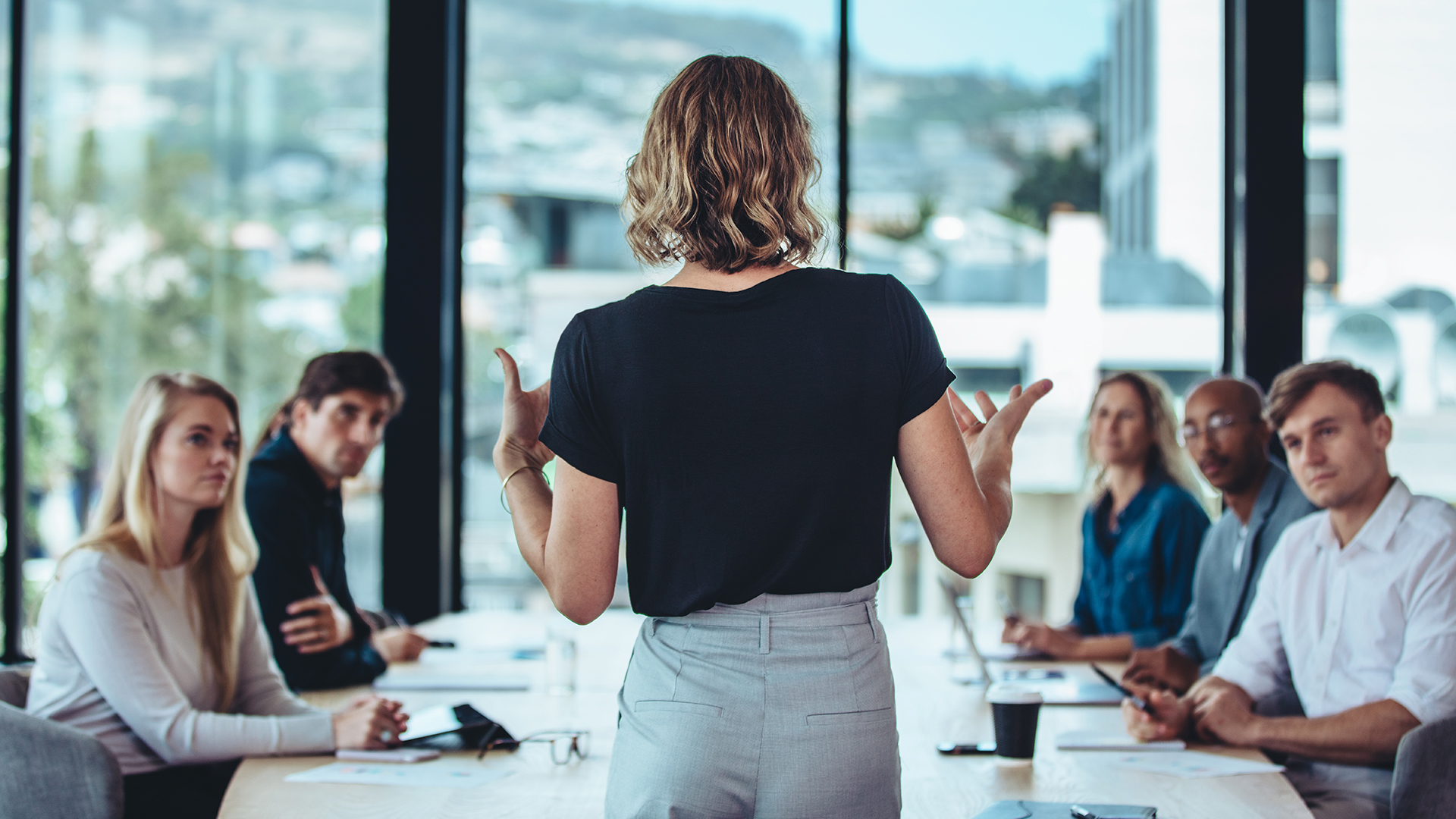 Mulher líder falando com uma equipe de trabalho
